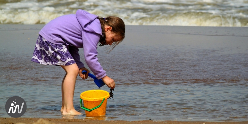 Enfant qui cherche attentivement des trésors dans la mer